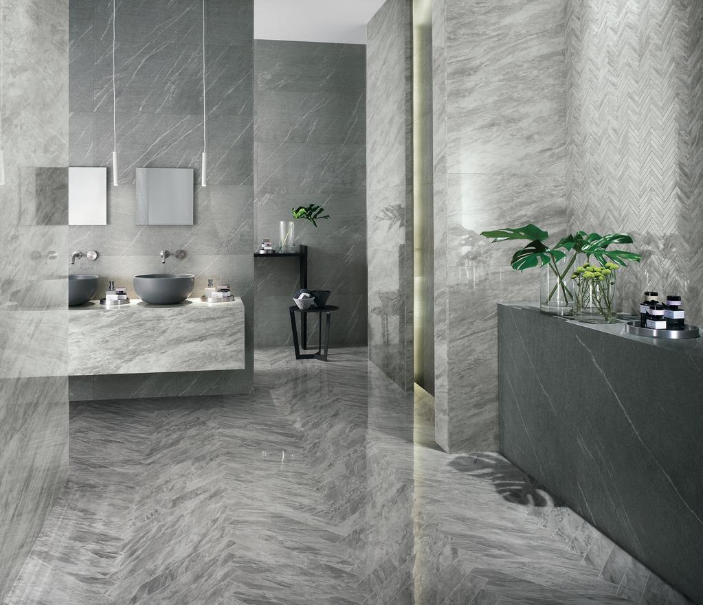 Elegantes Badezimmer mit grauen Fliesenverkleidungen, zwei runden Waschbecken, hängenden Spiegeln und Details von grünen Pflanzen.