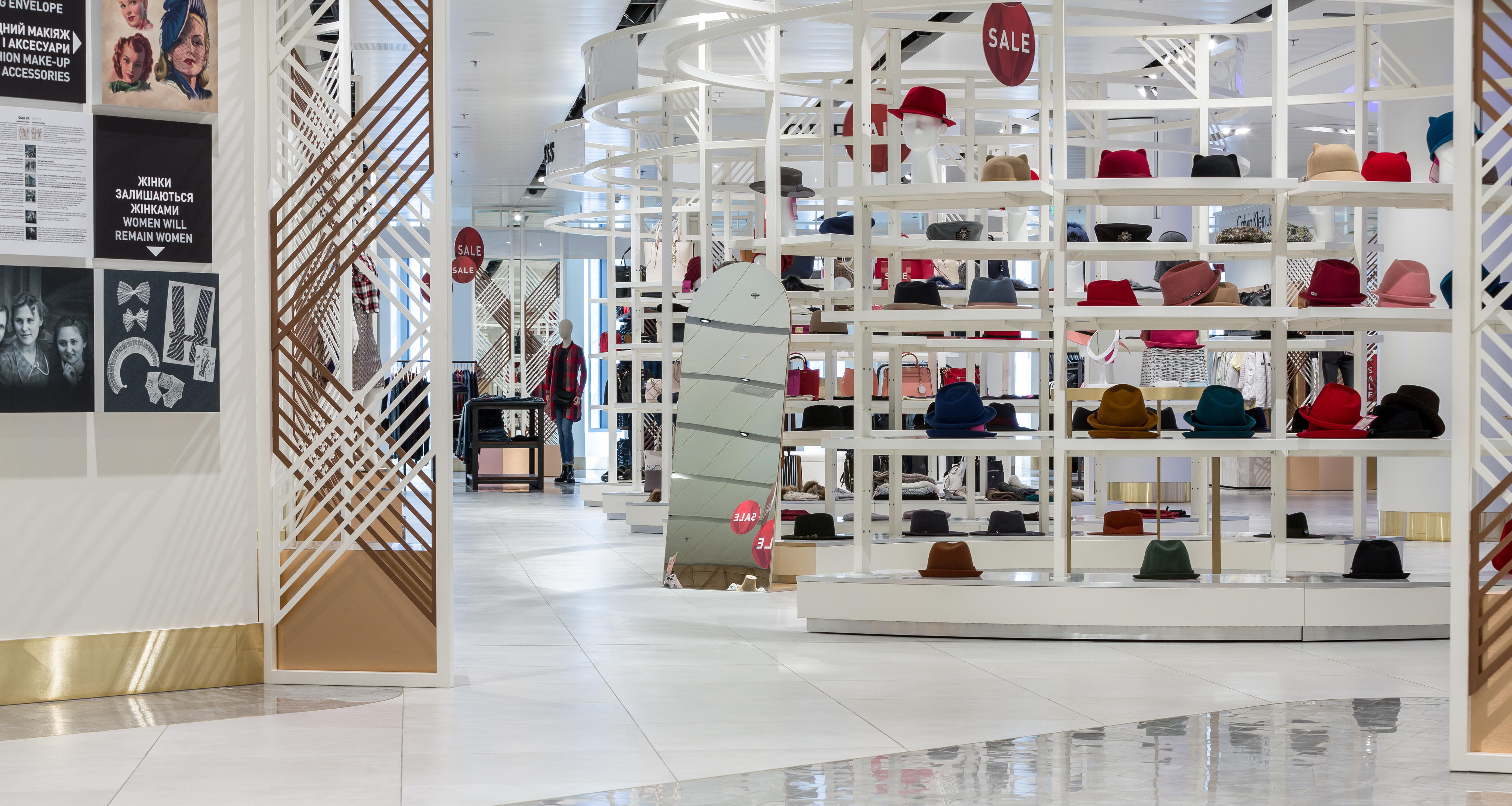 Interno di un centro commerciale moderno e futuristico con pavimenti lucidi, scaffali con cappelli e accessori in vendita. 