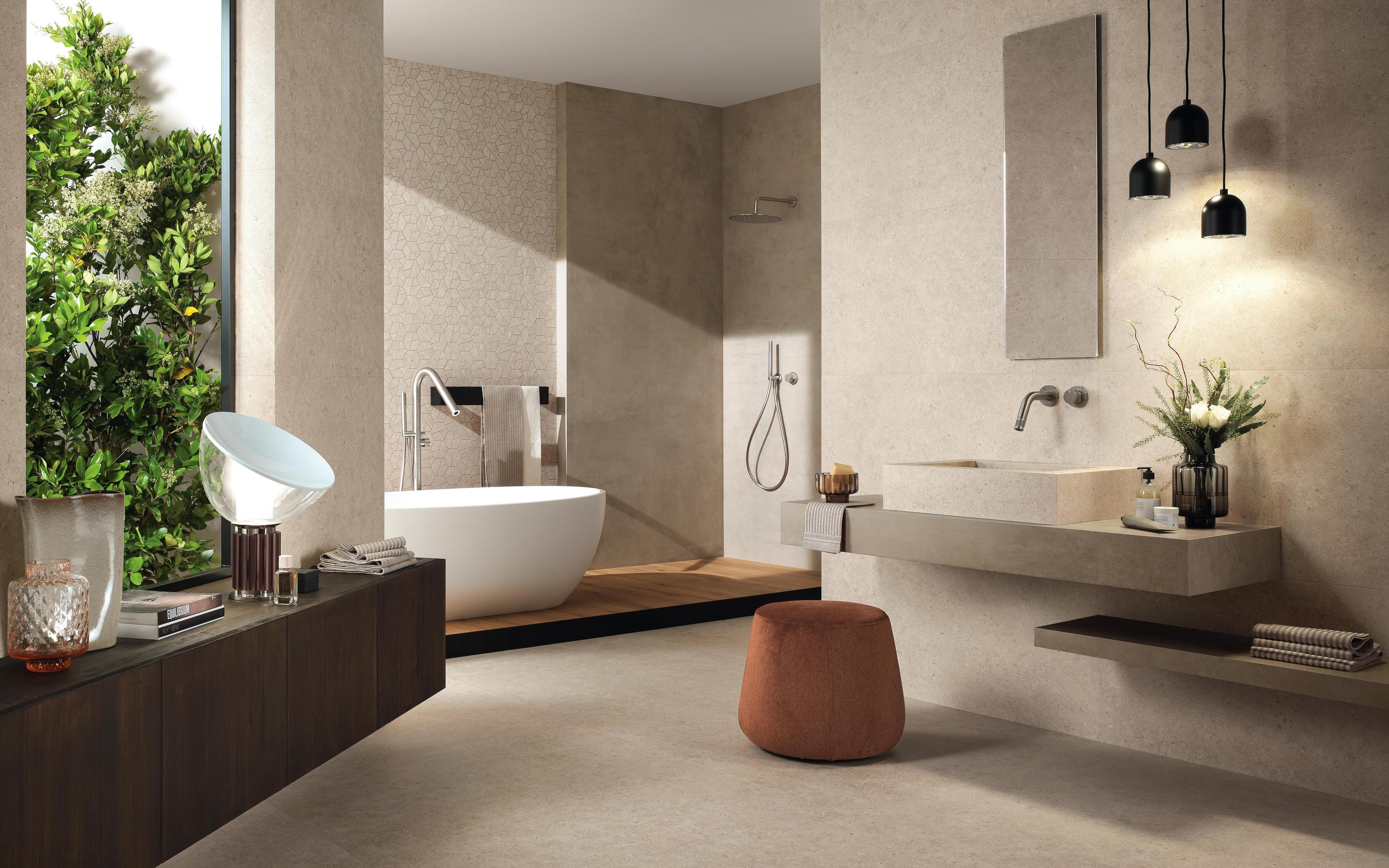 Elegantes Badezimmer mit weißer ovaler Badewanne, Waschbecken aus Feinsteinzeug und Holzdetails.