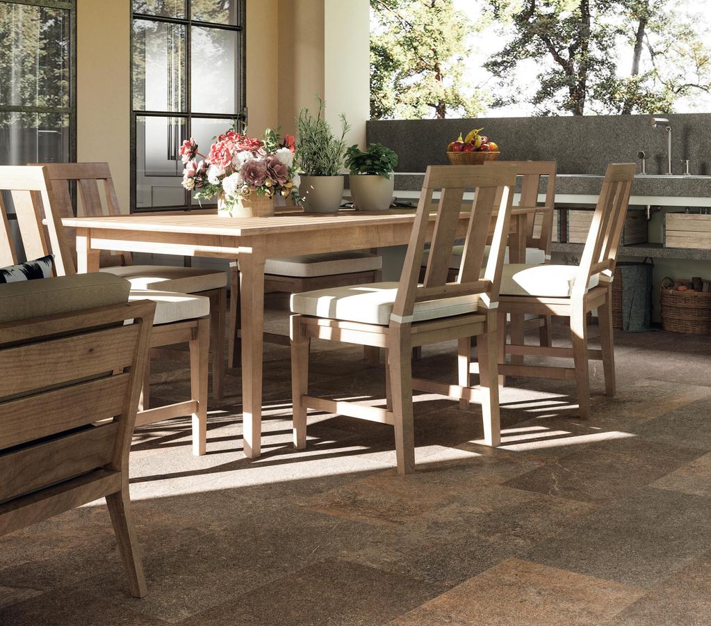 Patio arredato con piastrelle moderne di medio formato, mobili in legno e una cucina esterna completa di barbecue.f