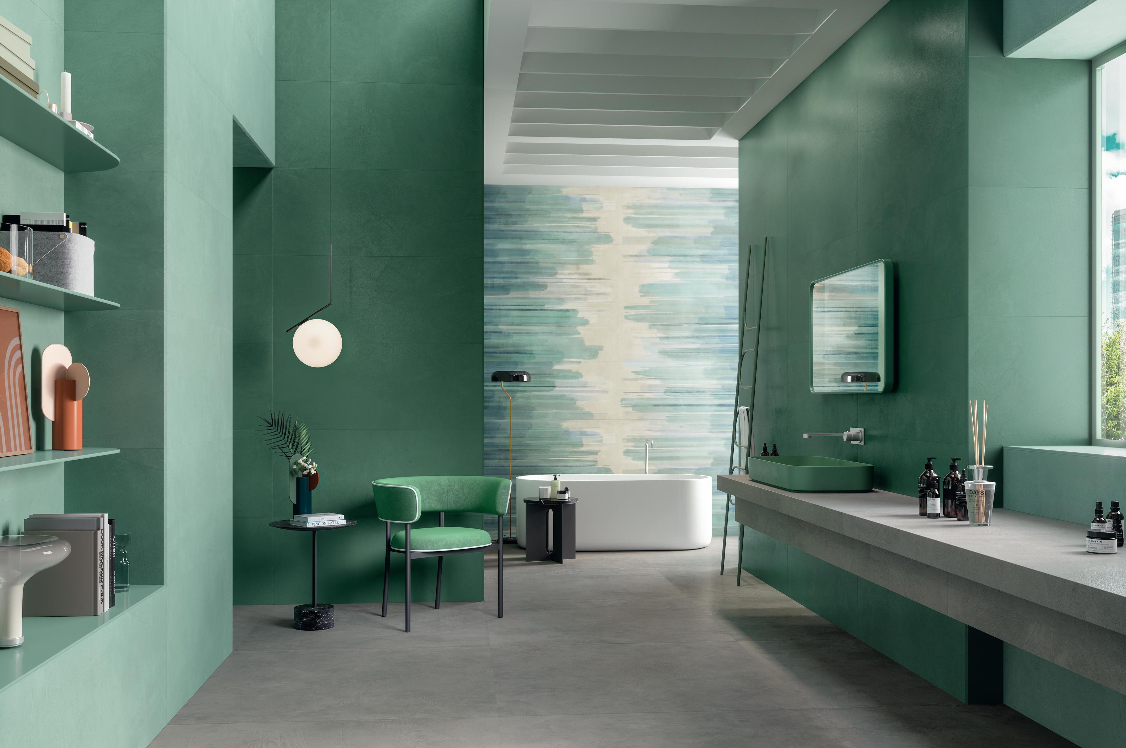Modern bathroom with porcelain tile floor effect cement, green walls and white bath.
