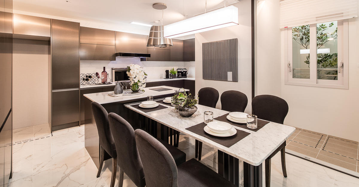Cocina y comedor de un lujoso apartamento coreano con mesa y suelos de mármol.