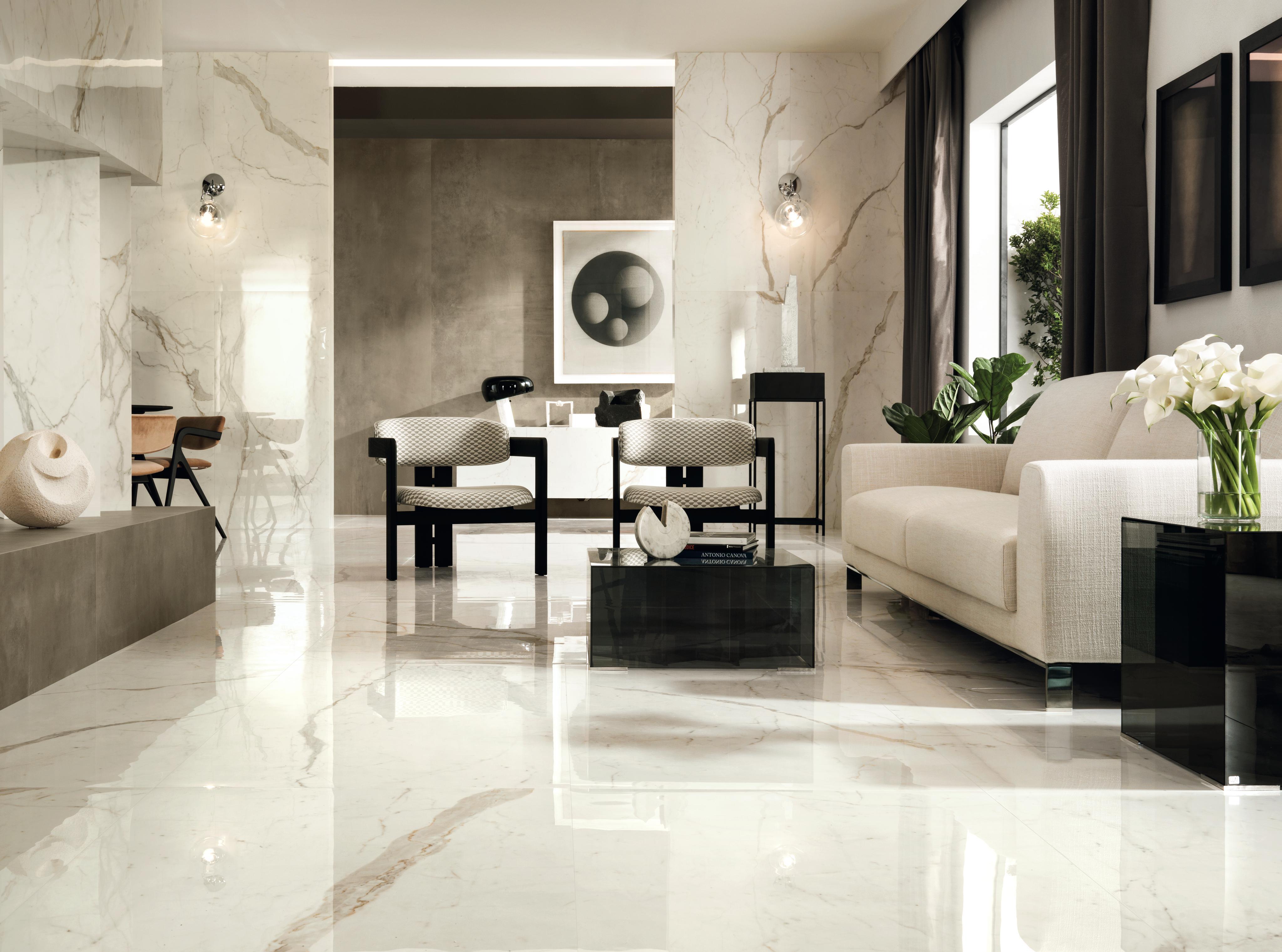 Elegante salón con revestimiento de mármol calacatta oro y detalles en mármol blanco y beige, que aportan a la estancia un ambiente lujoso y refinado.