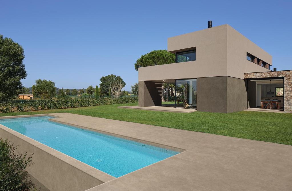 Villa avec revêtement de sol pour piscine extérieure en grès cérame effet terre crue.