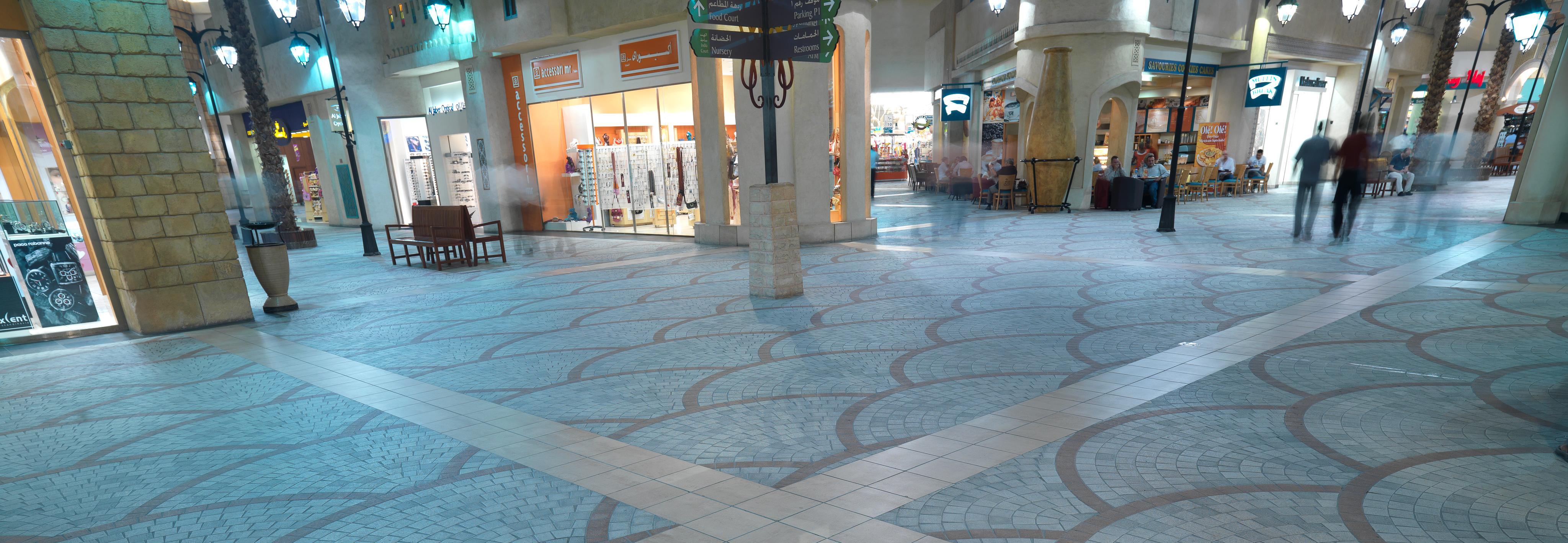 Pavimentos en el interior del centro comercial Ibn Battuta con motivos geométricos azules y grises.