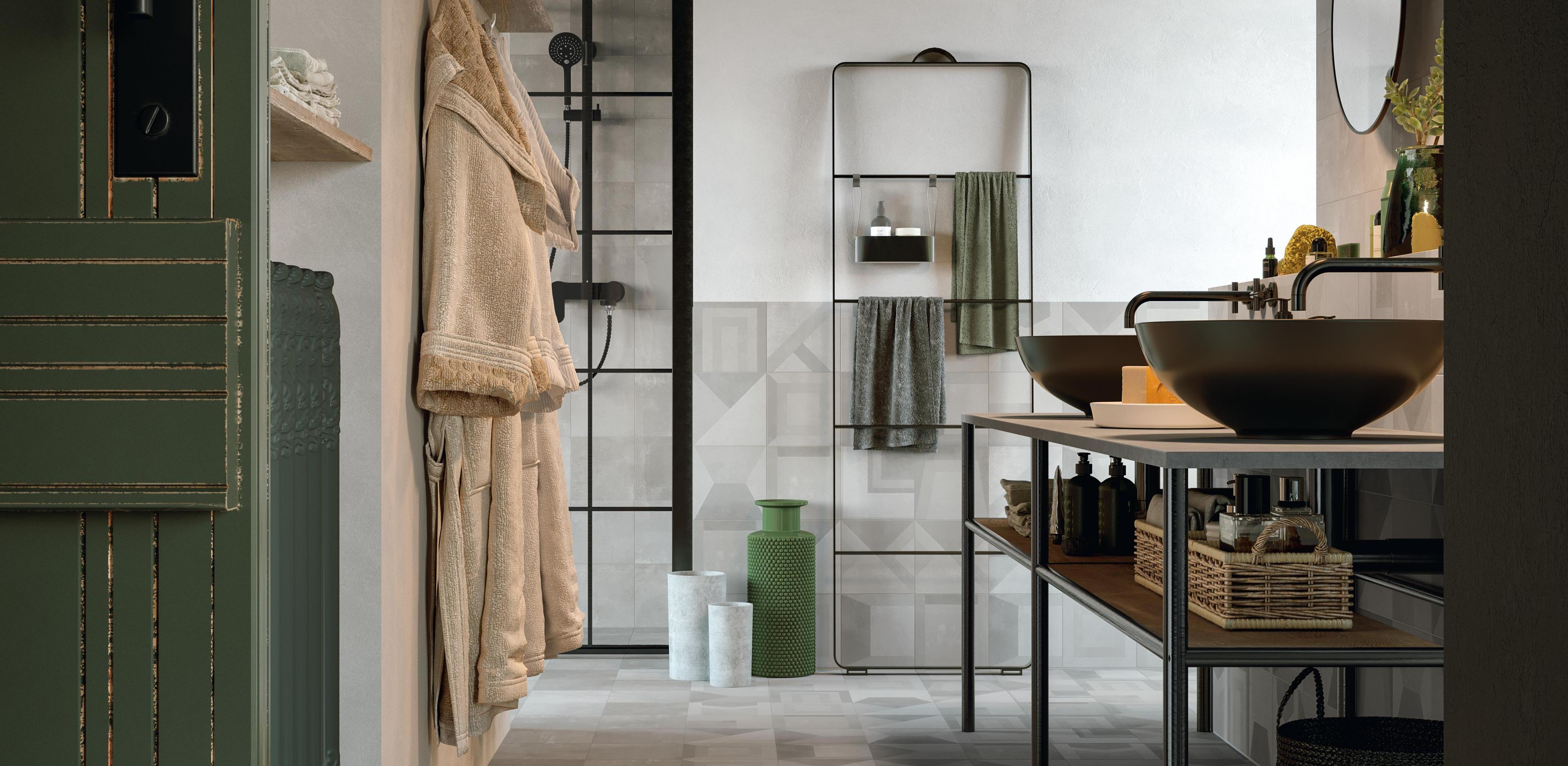Industrial style bathroom with porcelain floor effect concrete, shower, black washbasins and metal furniture.