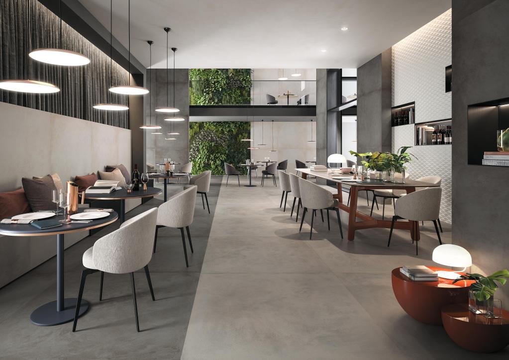 Modernes Restaurant mit grauem Fliesenboden, eleganten gedeckten Tischen, beigen Stühlen und einer grünen dekorativen Wand.