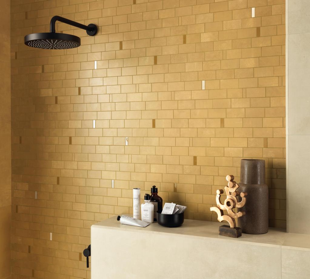 Shower with wall covered in yellow tiles, equipped with a black shower head.
