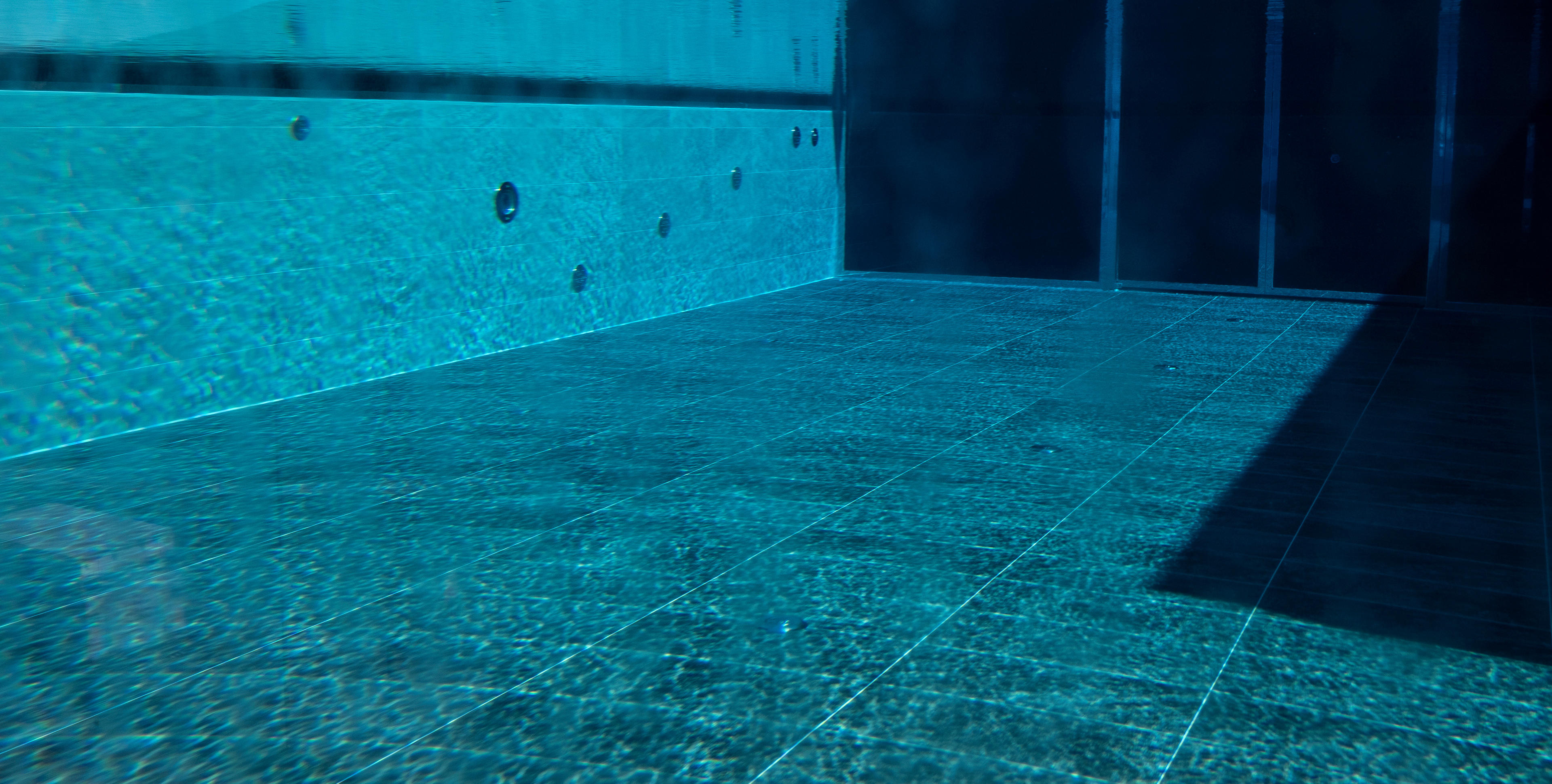Underwater view of the indoor pool of the Hotel Terentnerhof with blue tiles.