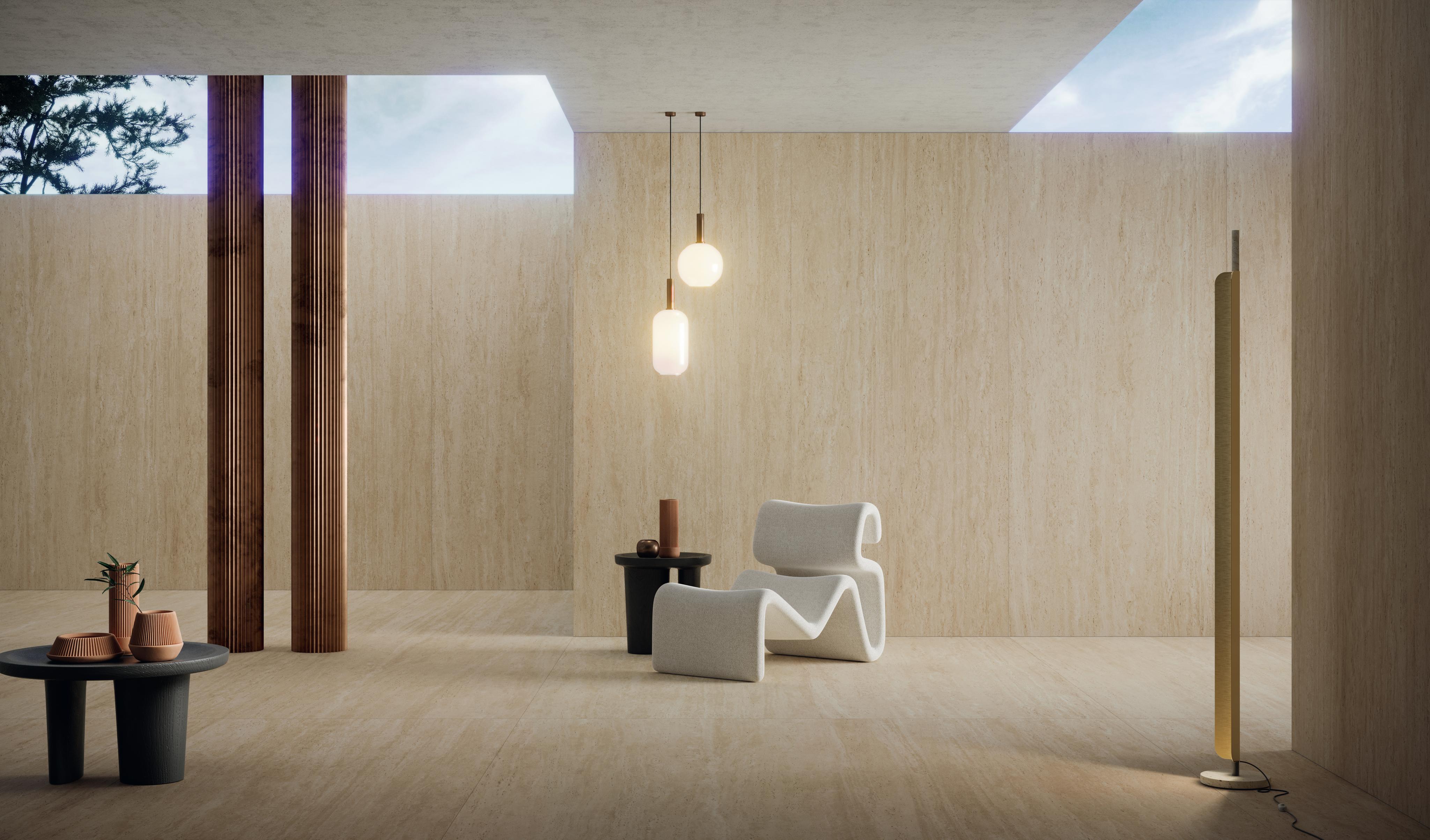 Elegant interior with travertine floor and walls, modern white chair, black tables with decorative objects and hanging lights. 