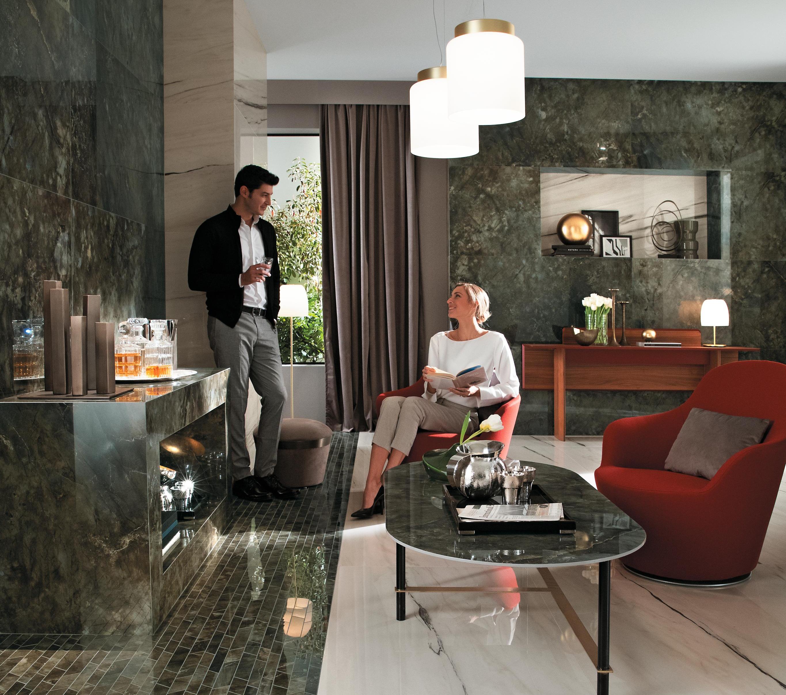 Design-Wohnzimmer mit Marmor-Interieur, moderne Möbel und ein Paar, das in einer gemütlichen Umgebung plaudert.