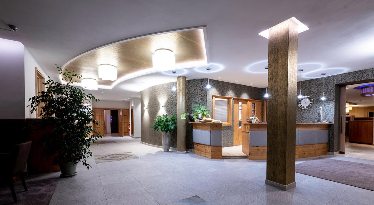 Elegant reception of the Hotel Terentnerhof with modern decoration, soft lighting and decorative plants.