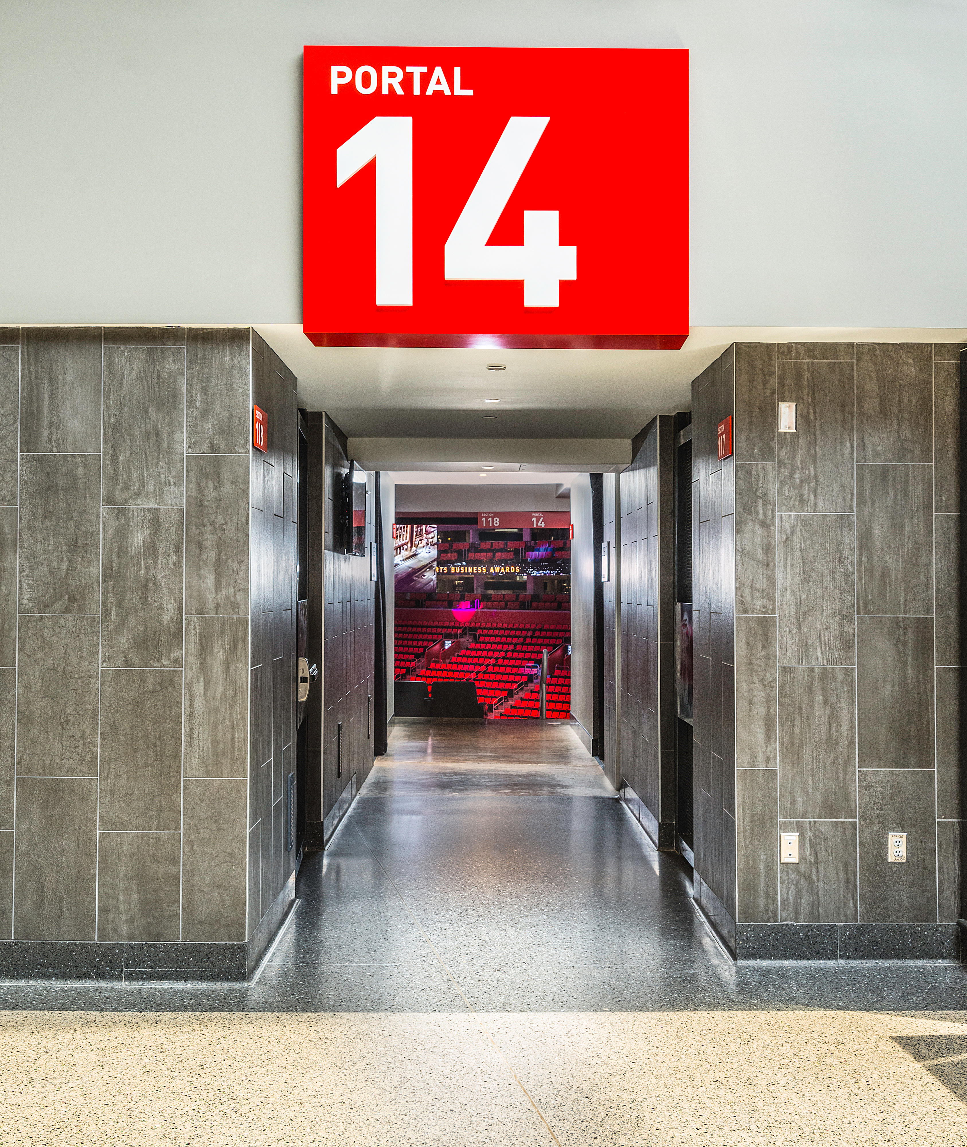 Entrada del portal 14 de la arena Little Caesars con una vista clara sobre las tribunas interiores rojas.