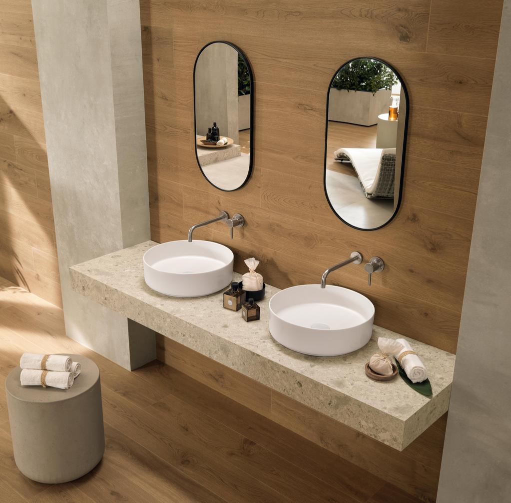 Bathroom with walls and floors in wood effect with double white sink and oval mirrors. 